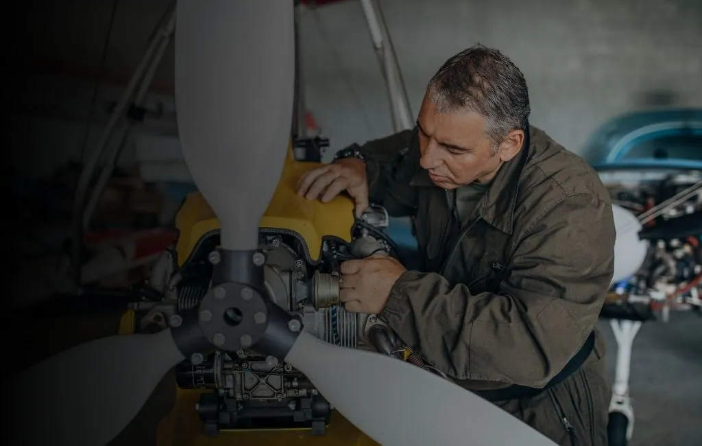 Aerospace technician working on an aircraft propeller and engine assembly