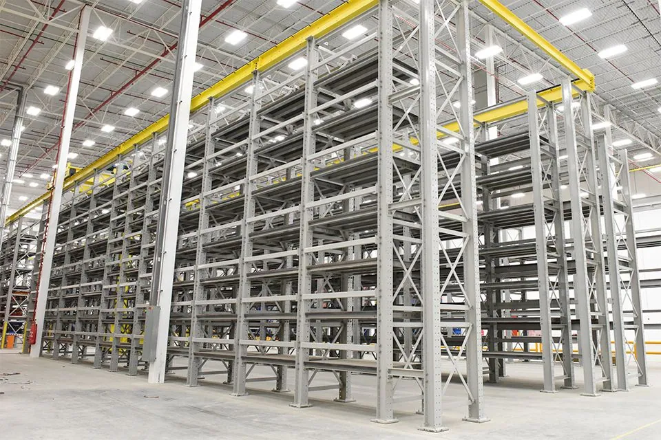 Automated unit load pallet AS/RS crane retrieving palletized loads in a high-density racking aisle